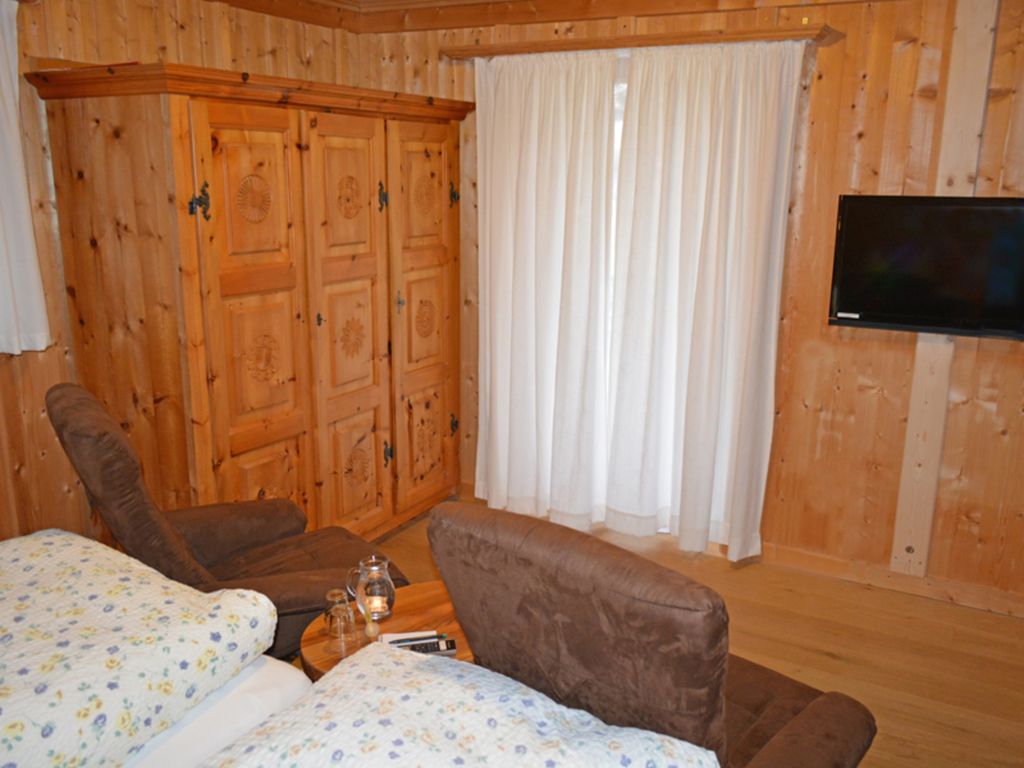 Doppelzimmer mit höher gestellten Betten und Flachbildschirm