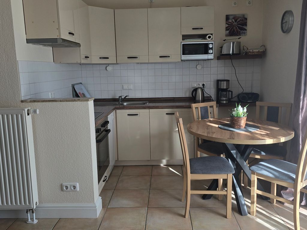Voll ausgestattete Küche mit gemütlichem Essplatz in der Ferienwohnung Sanddorn in Karlshagen auf der Insel Usedom  ideal für gemeinsame Mahlzeiten während Ihres Ostseeurlaubs.