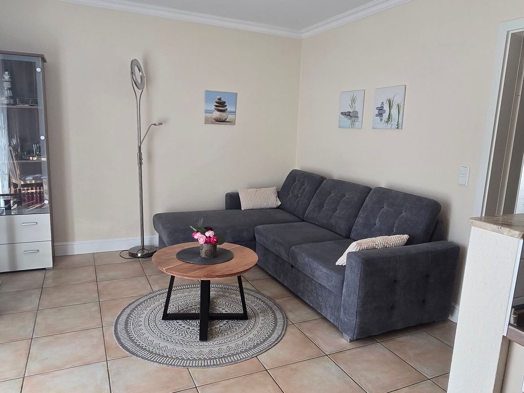 Gemütliches Wohnzimmer der Ferienwohnung Sanddorn in Karlshagen auf der Insel Usedom mit großzügiger Sofalandschaft, TV und offenem Wohnbereich  perfekt zum Entspannen nach einem Tag am Ostseestrand.