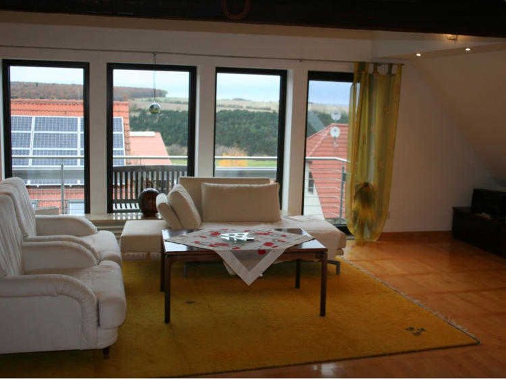 Wohnbereich mit Sitzecke und Zugang zum Balkon