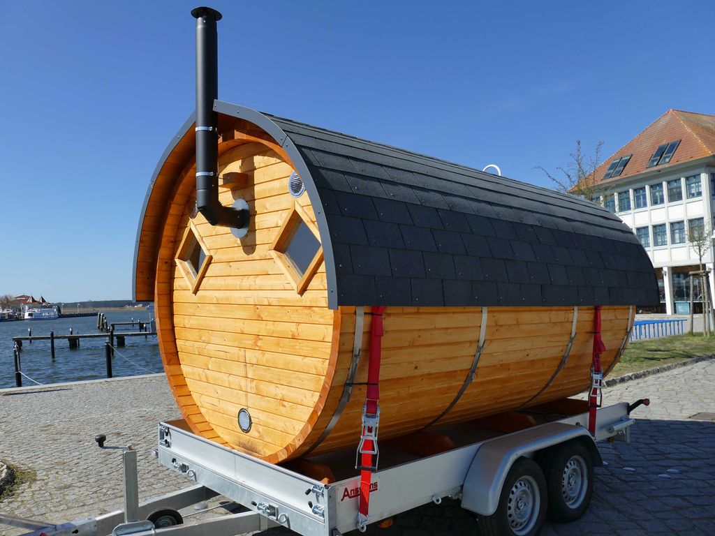 Die mobile Fass-Sauna, am Hafen des Ostseebas Karlshagen. Die beiden Fenster hinter dem Holzofen sorgen für natürliches Licht im Saunaraum.