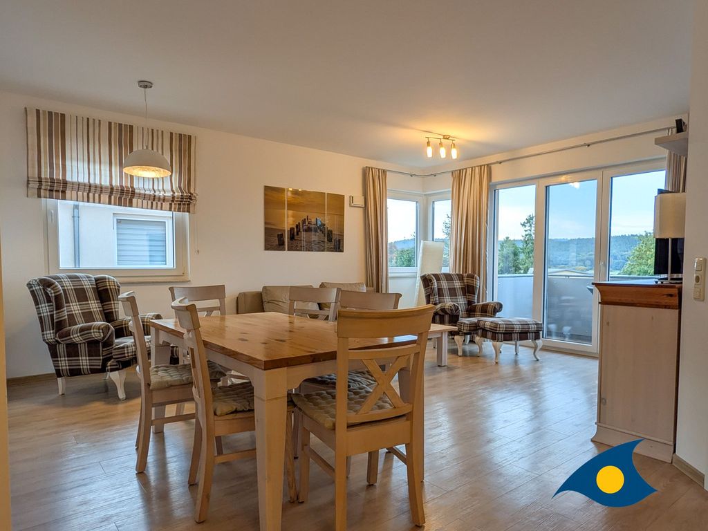 großer Wohnbereich mit offener Küche und Zugang zum Balkon