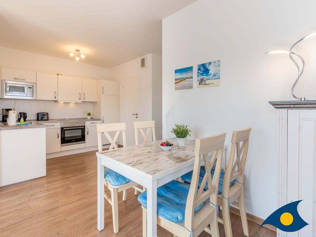 großer Wohnbereich mit Zugang zum Balkon und offener Küche