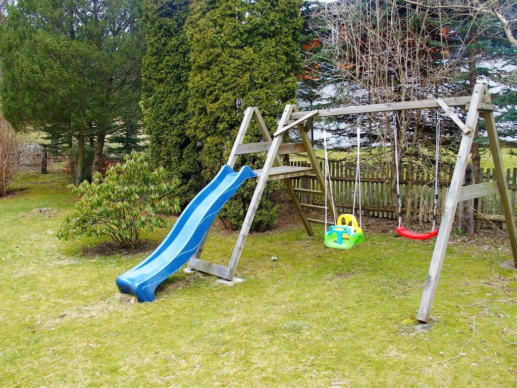 Im Garten wartet eine Spielecke mit Spielgeräten auf die Kids.