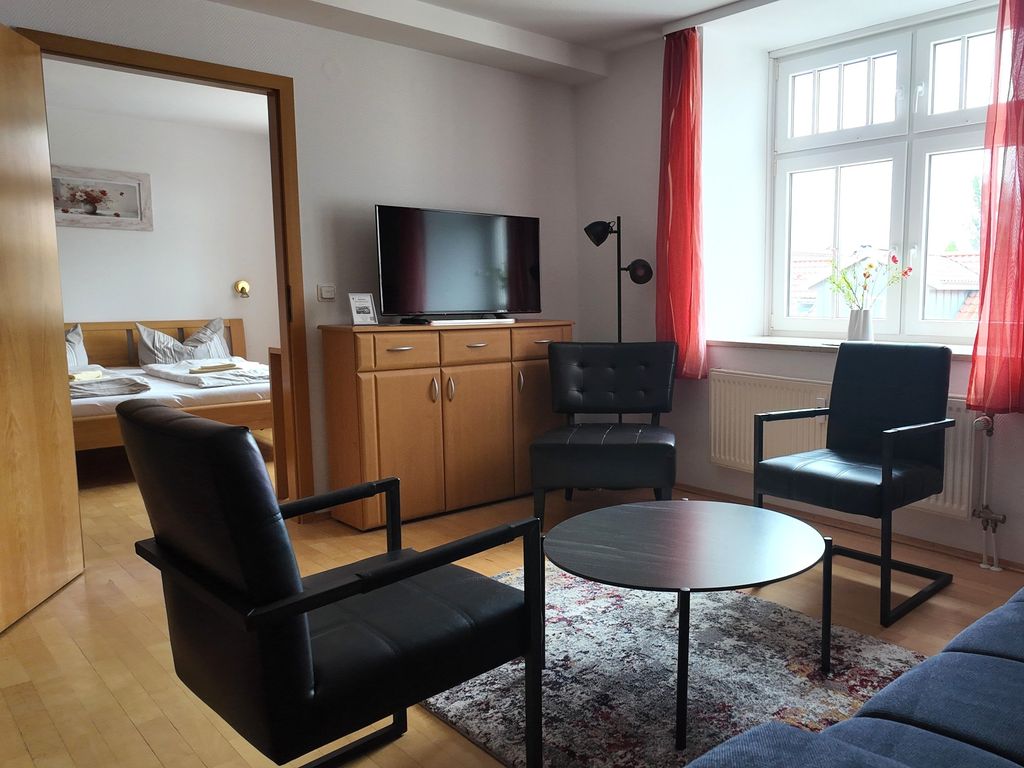 Der Wohnbereich mit gemütlicher Couch, Sesseln und TV