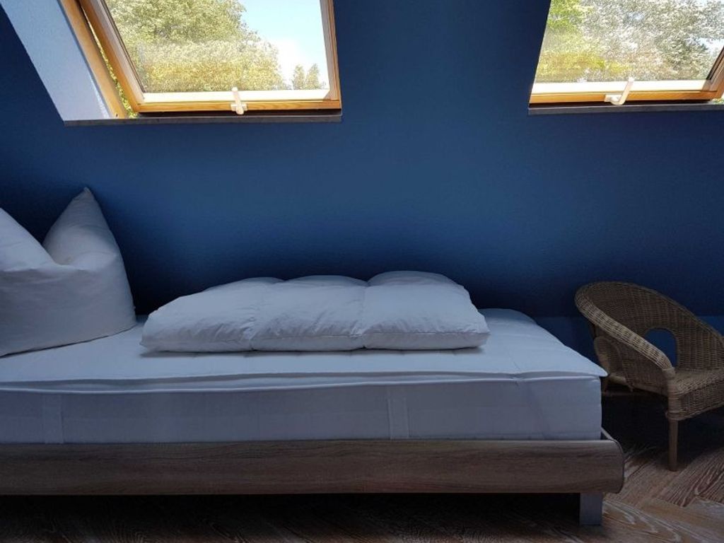 Ruhiges Schlafzimmer mit gemütlichem Bett und stilvoller Farbgestaltung für erholsamen Schlaf.