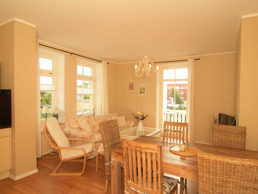 Der Wohnbereich mit gemütlicher Couchgarnitur, Essecke und Zugang zum Balkon