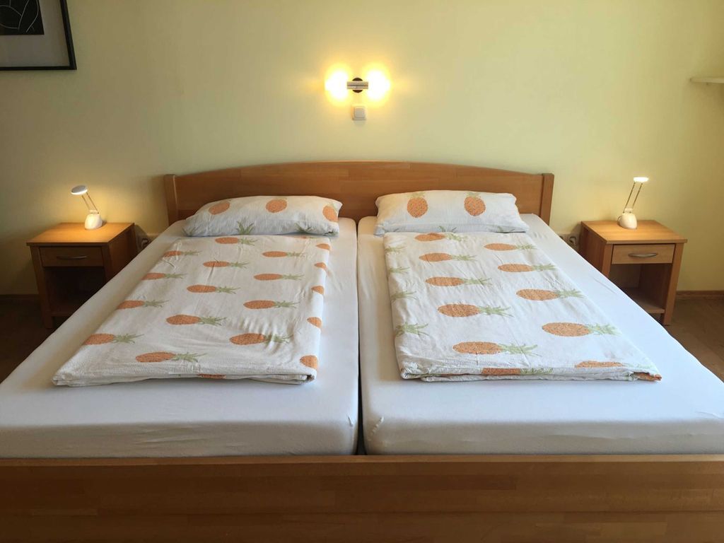 Erster Schlafraum mit Doppelbett und schöner Beleuchtung und Balkon
