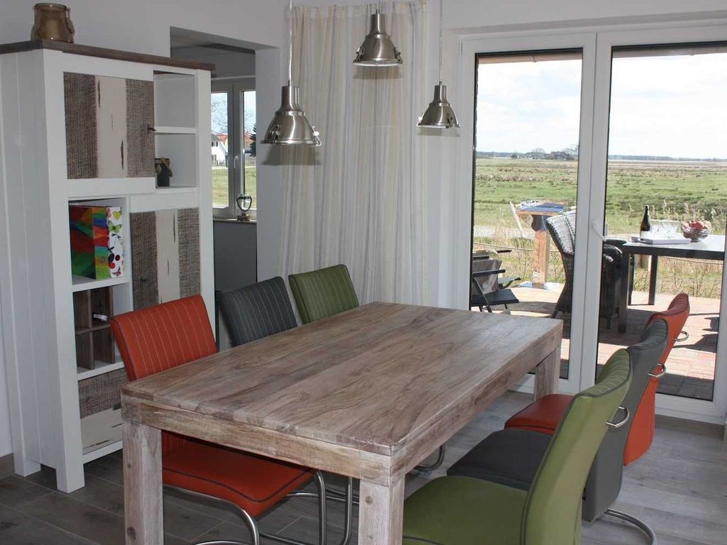 Das Ferienhaus Kormoran im Ostseebad Karlshagen auf der Insel Usedom zeigt einen hellen Essbereich mit großem Holztisch und sechs Sitzplätzen.