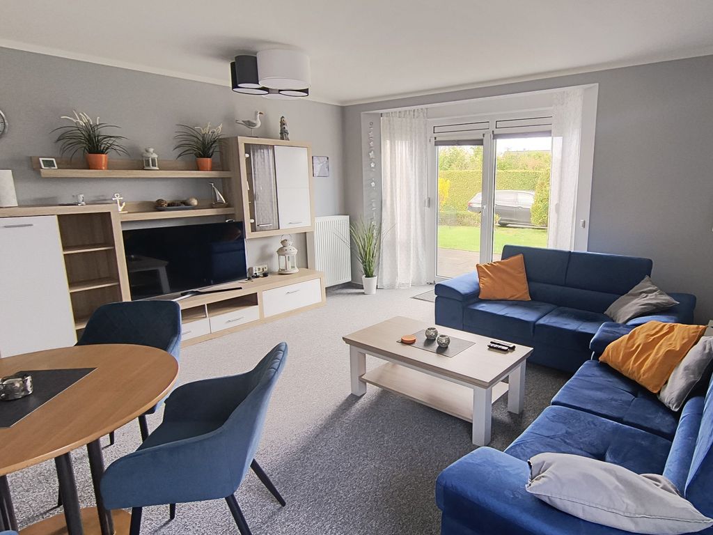 Der moderne Wohnbereich mit Couchgarnitur und Zugang zur großen Terrasse