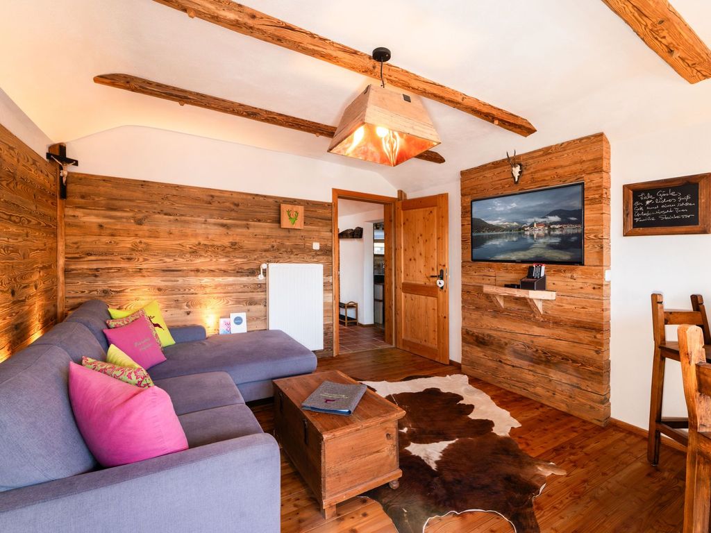 gemütliches Wohnzimmer mit Einbauten aus echtem Altholz und Smart-TV