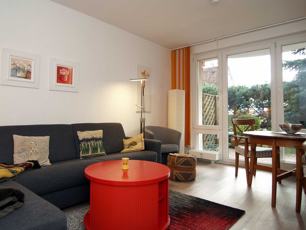 Das Wohnzimmer mit einer Schlafcouch und dem Zugang zur Terrasse