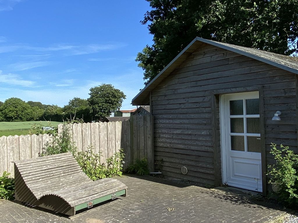 Große Relaxliege vor dem Saunahäuschen im Garten
