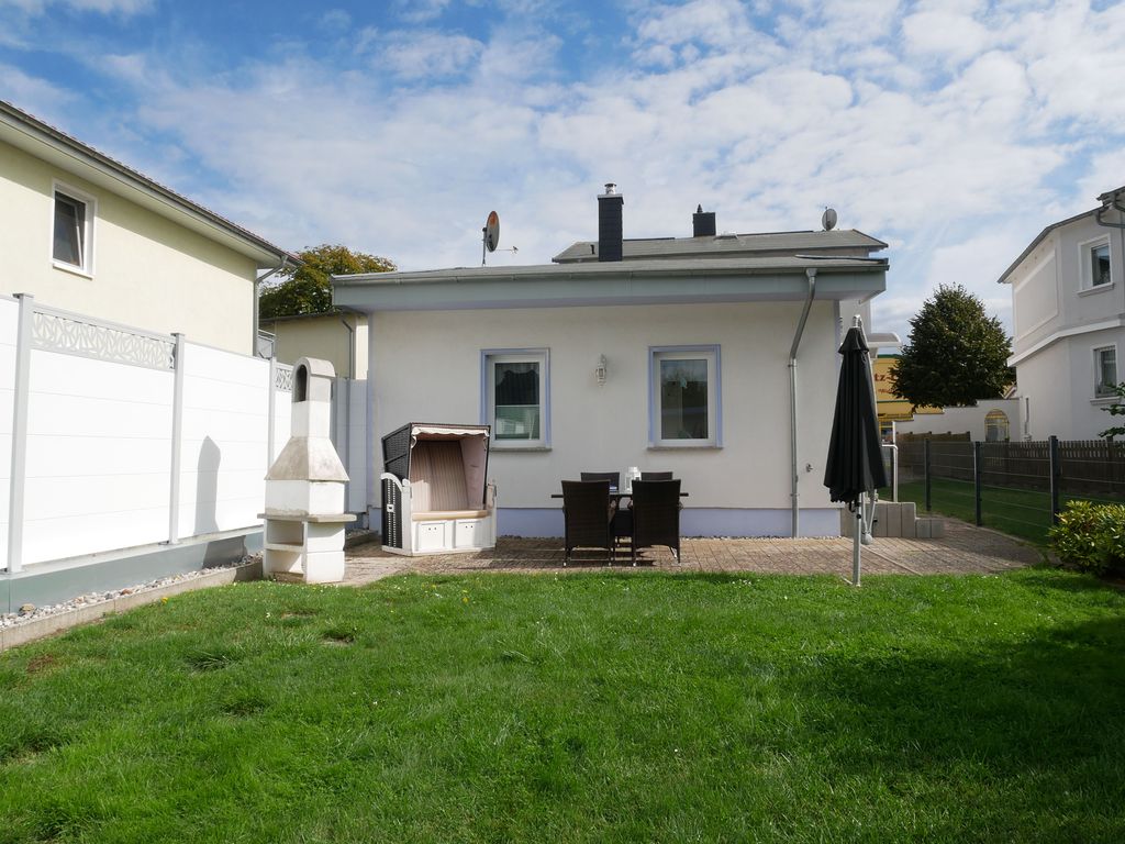umzäunter Garten mit Terrasse und Fahrradschuppen