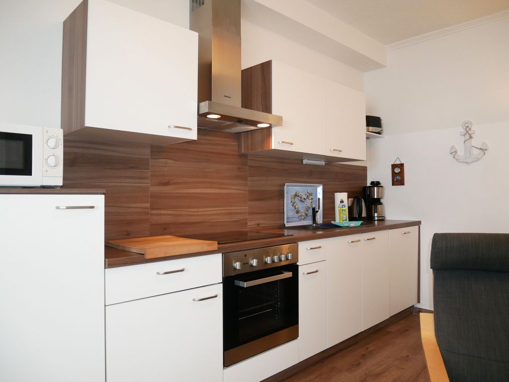 Wohnzimmer mit offener Küche, Essplatz und Kamin