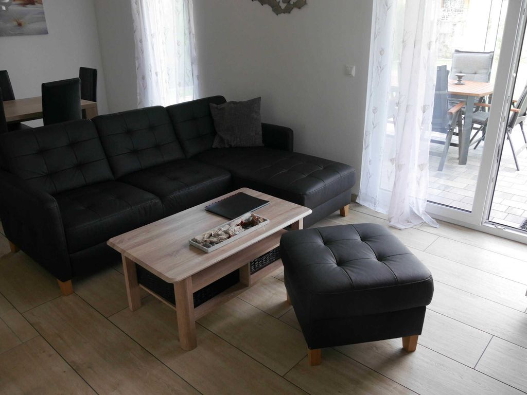 Wohnbereich mit Essplatz - 
Das Ferienhaus Möwenkoje im Ostseebad Karlshagen auf der Insel Usedom zeigt den Wohnbereich mit Sitzgruppe, Esstisch und Zugang zur Terrasse.