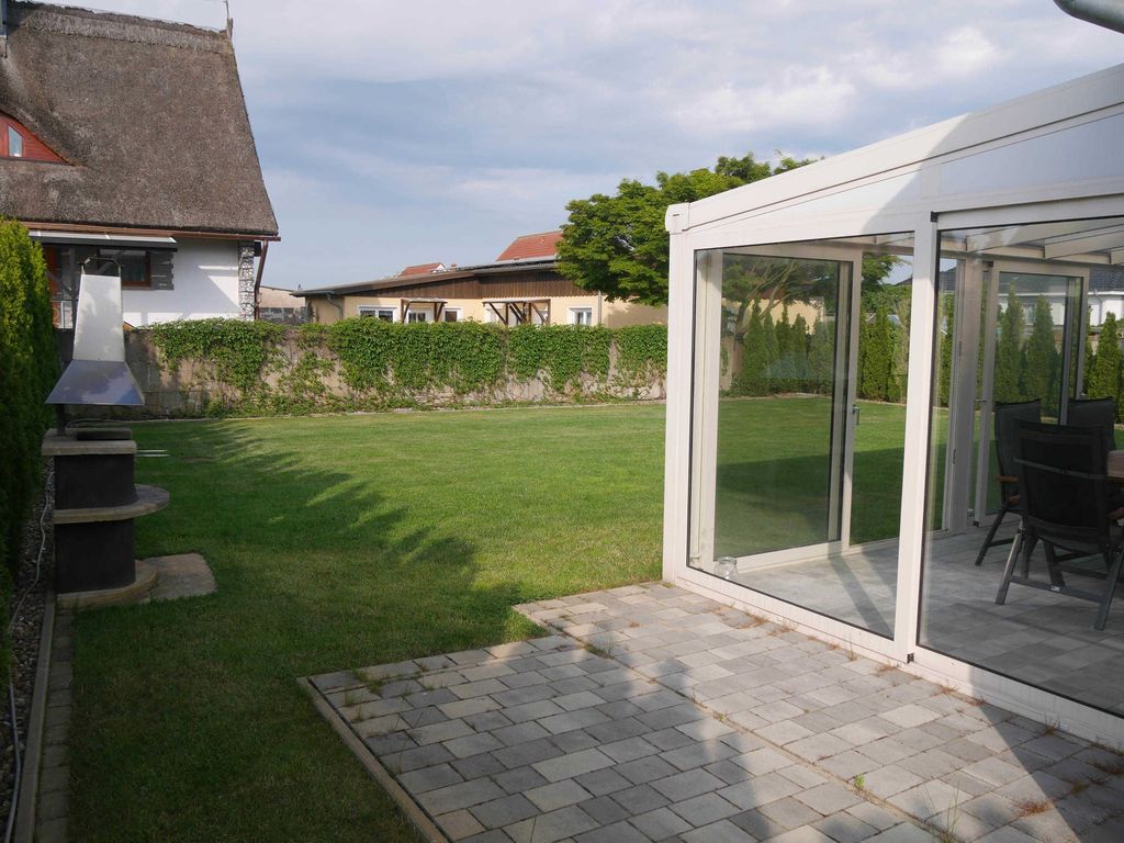 Außenansicht des Ferienhauses -###br###Das Ferienhaus Möwenkoje im Ostseebad Karlshagen auf der Insel Usedom zeigt die Rückseite des Hauses mit Wintergarten, Terrasse und Garten.