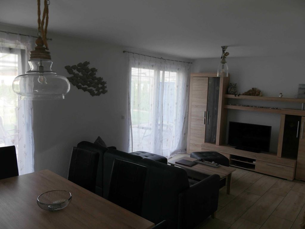 Wohnzimmer mit Sitzgruppe - 
Das Ferienhaus Möwenkoje im Ostseebad Karlshagen auf der Insel Usedom zeigt ein gemütliches Wohnzimmer mit Ledersitzgruppe, Couchtisch und Fernseher.