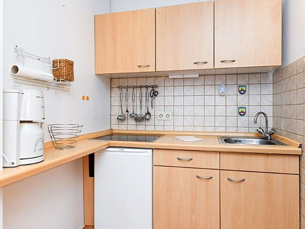 Wohnzimmer mit räumlich abgeteilter Küchennische