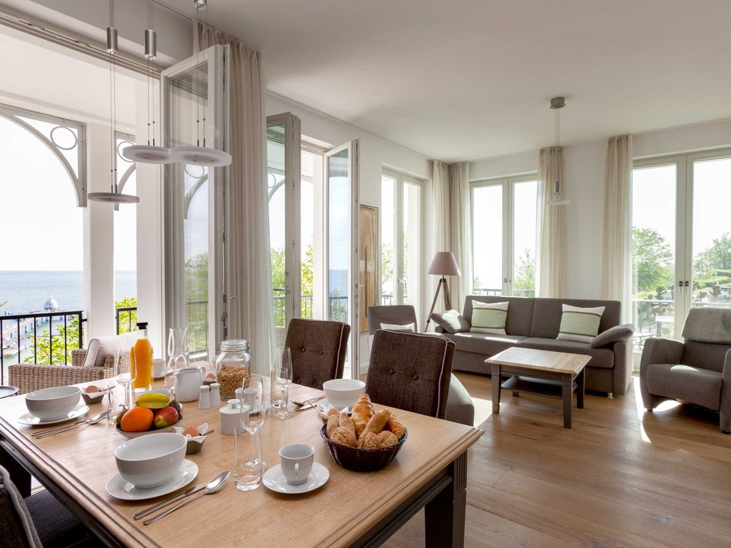 Lichtdurchfluteter Ess- und Wohnbereich mit zwei Balkonen und Blick auf die Ostsee und Selliner Seebrücke