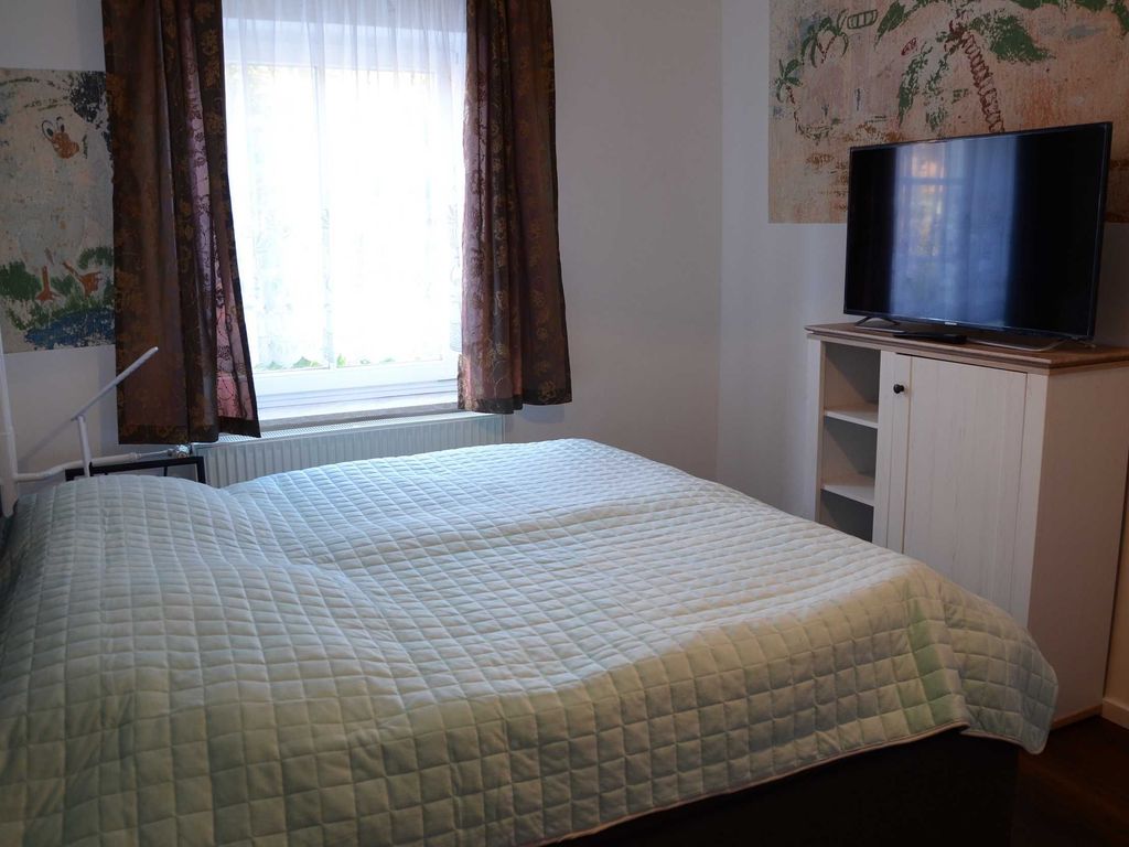Schlafzimmer im Ferienhaus Hannahliese in Karlshagen auf der Insel Usedom mit großem Doppelbett und Kleiderschrank.