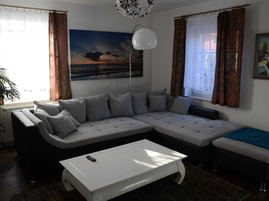 Wohnzimmer im Ferienhaus Hannahliese in Karlshagen auf der Insel Usedom mit großer Eckcouch und Fernseher.