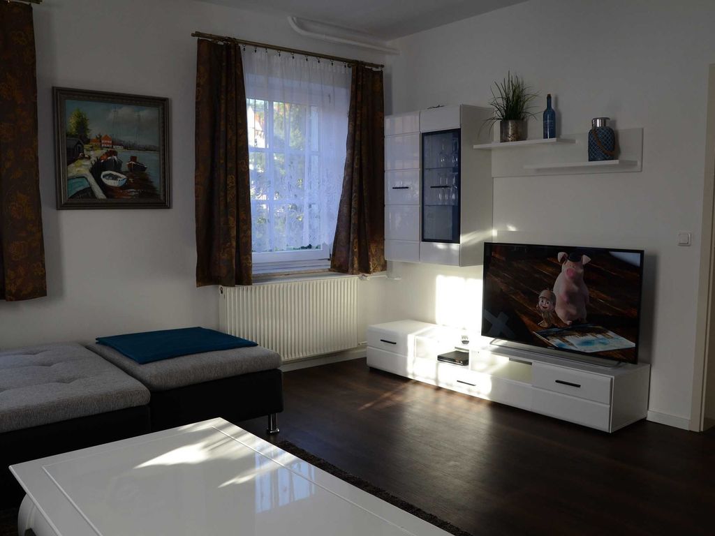 Gemütlicher Wohnbereich im Ferienhaus Hannahliese in Karlshagen auf der Insel Usedom mit Sitzgruppe und Fernseher.