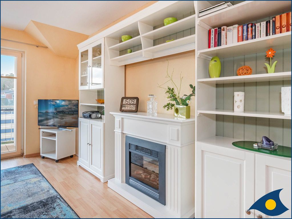Wohnzimmer mit offener Küche und Zugang zum Balkon
