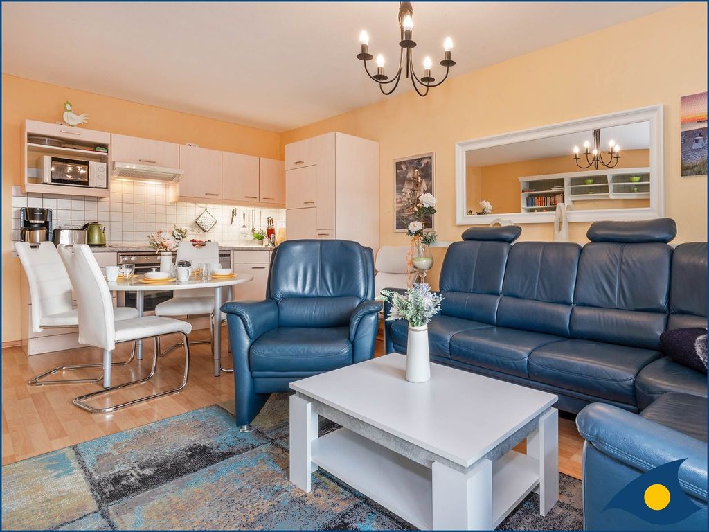 Wohnzimmer mit offener Küche und Zugang zum Balkon