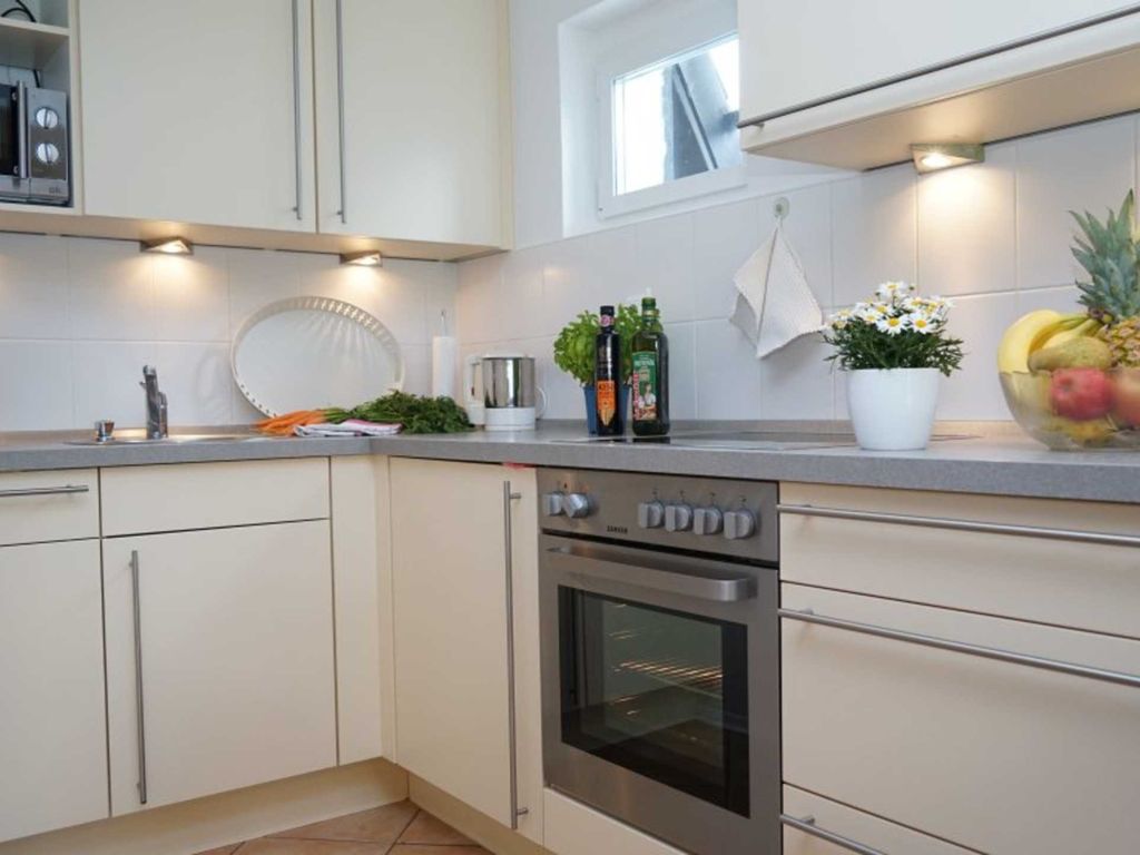 Voll ausgestattete, moderne Einbauküche mit Backofen und Spülmaschine.