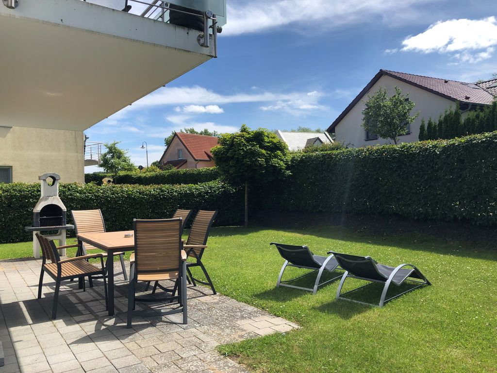 Terrasse mit Sonnenliegen und Gartenmöbeln
