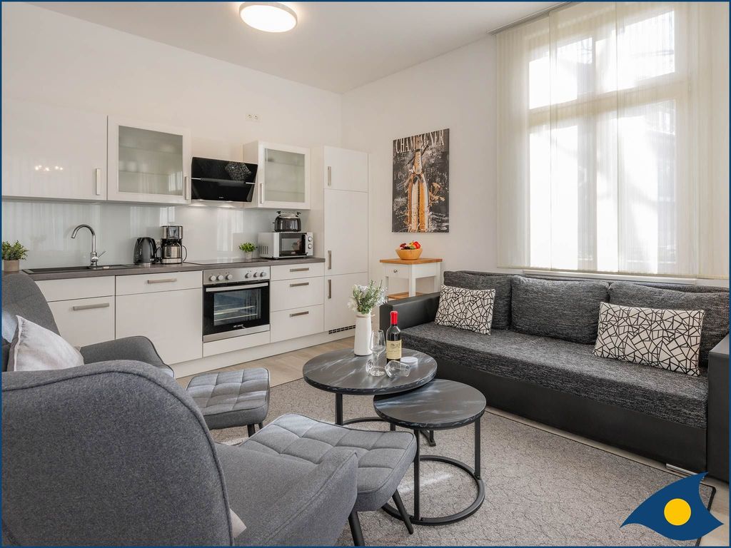 Wohnzimmer mit offener Küche und Zugang zur Terrasse