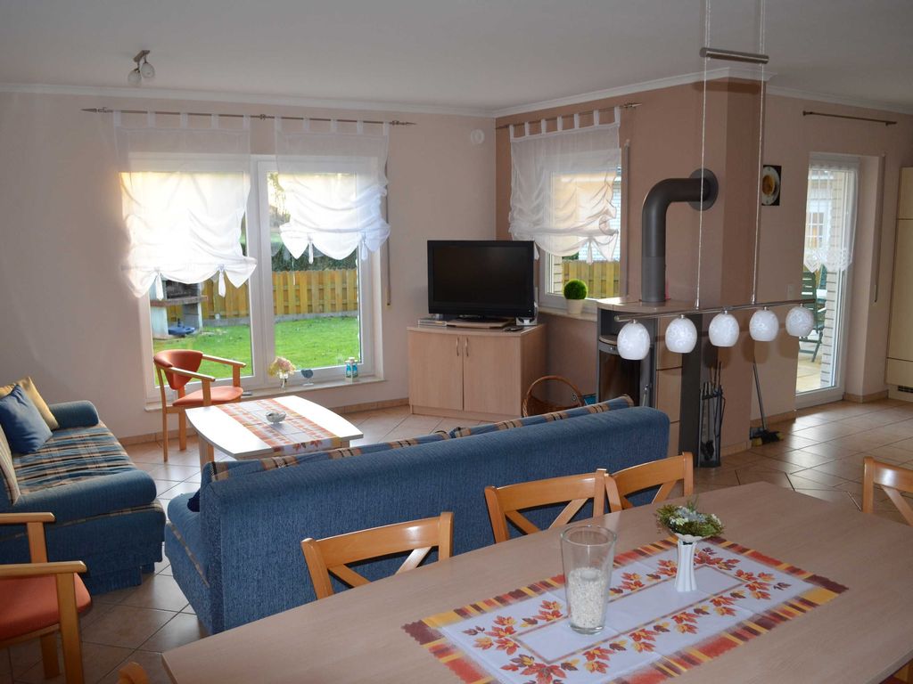 Großzügiger Wohn- und Essbereich mit gemütlicher Sofalandschaft, Kaminofen, TV und direktem Zugang zur Terrasse. Der helle Raum bietet viel Platz für entspannte Urlaubstage im Ferienhaus Bernstein in Karlshagen auf Usedom
