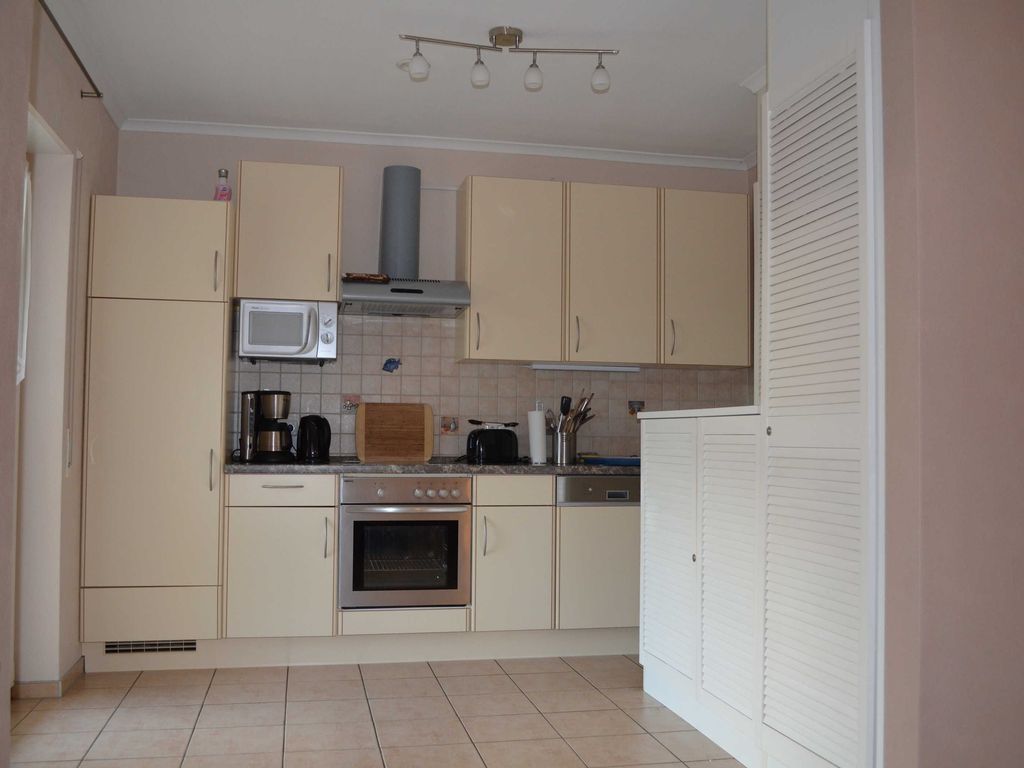 Moderne und lichtdurchflutete Küche mit Herd, Mikrowelle, Kaffeemaschine und umfangreicher Ausstattung. Viel Platz zum Kochen, Genießen und gemeinsamen Verweilen im Ferienhaus Bernstein in Karlshagen auf Usedom.