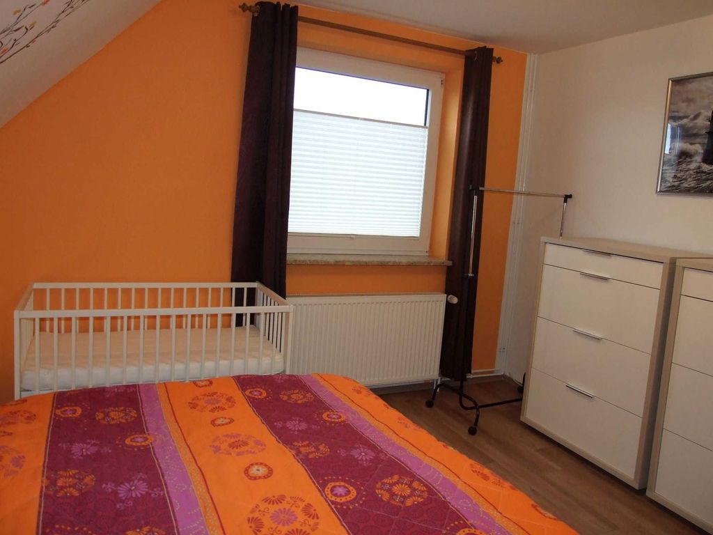 Schlafzimmer mit Doppelbett und Kinderbett im OG