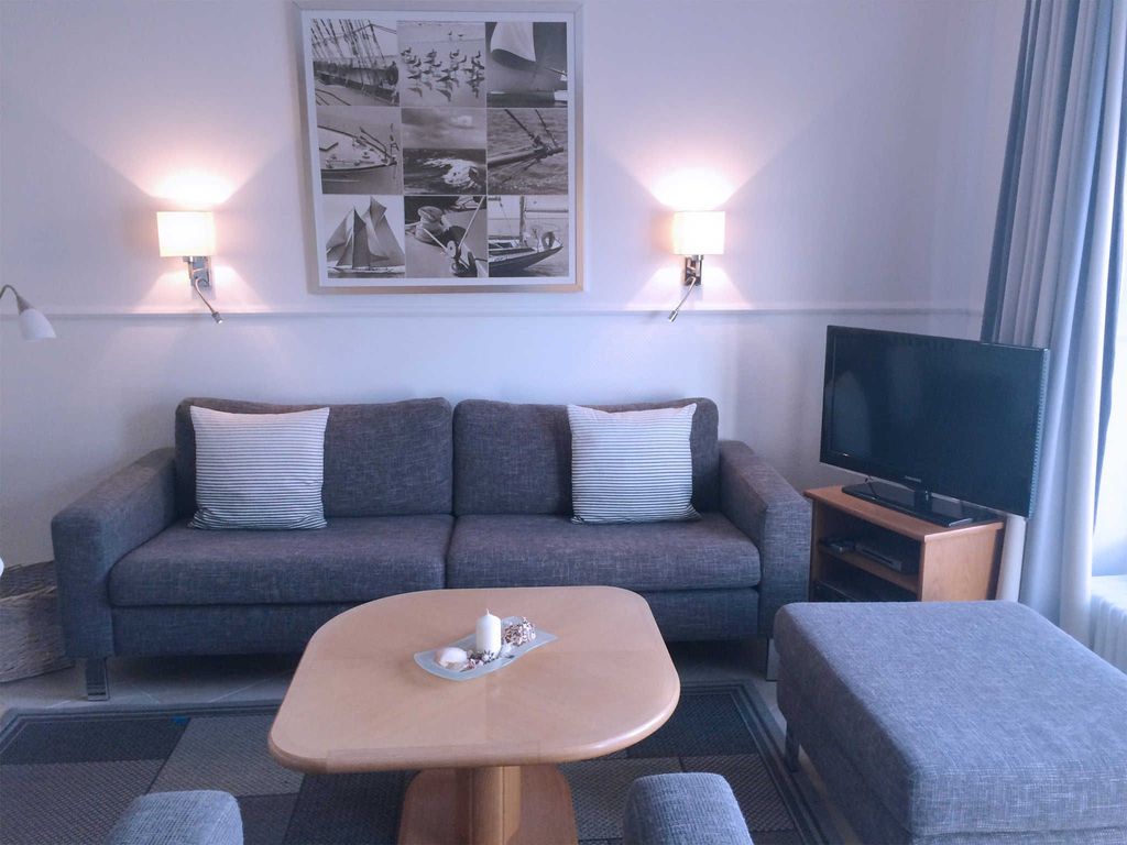 Moderne Wohnzimmergarnitur mit Flachbildschirm und direktem Zugang zu Terrasse und Garten