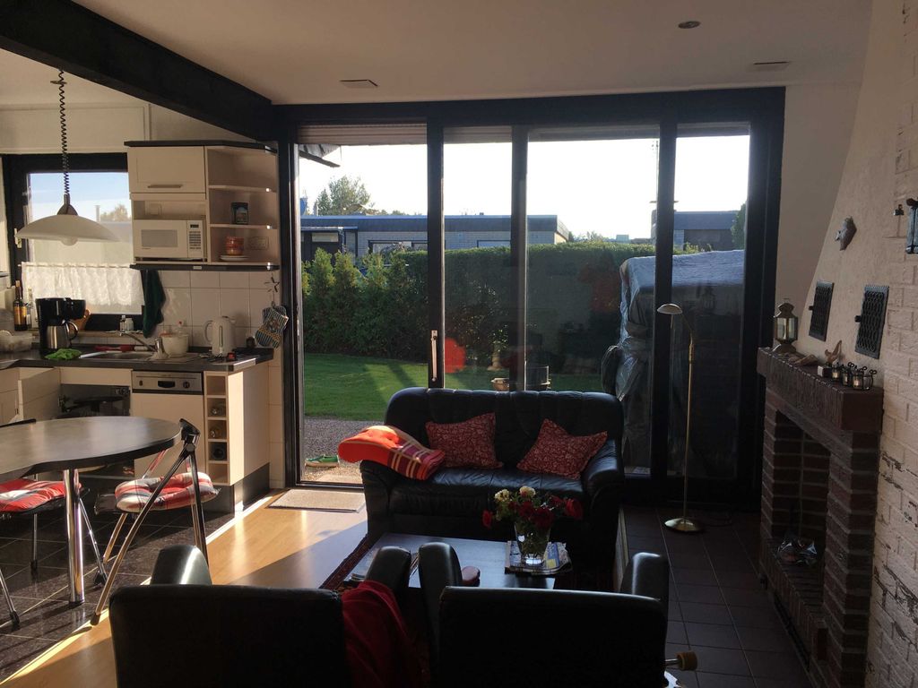 Küche und Sitzecke vor dem Kamin mit Zugang zur Terrasse in den Garten