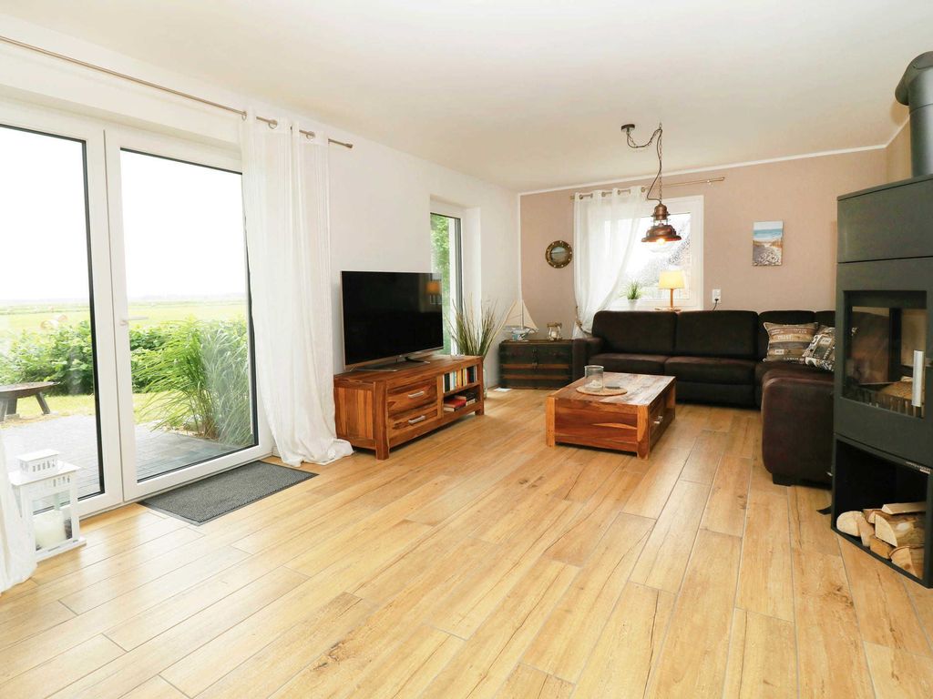 Wohnzimmer im Ferienhaus Hinnerk in Karlshagen auf der Insel Usedom mit großer Sitzgruppe, Fernseher und Kaminofen.