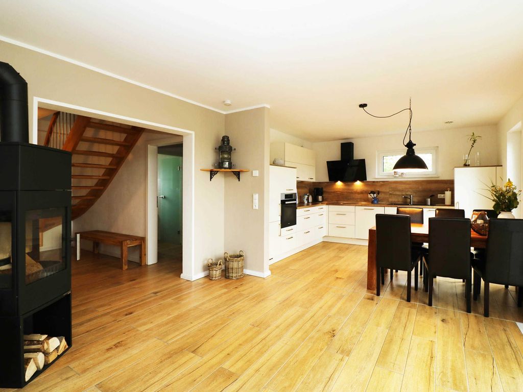 Offene Küche im Ferienhaus Hinnerk in Karlshagen auf der Insel Usedom mit moderner Küchenzeile und Elektrogeräten wie Herd, Backofen, Kühlschrank, Geschirrspüler, Mikrowelle und Kaffeemaschine.