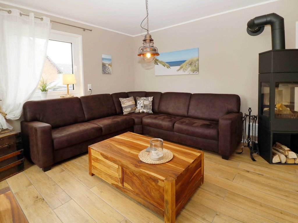 Wohnbereich im Ferienhaus Hinnerk in Karlshagen auf der Insel Usedom mit Sitzgruppe und Kaminofen.