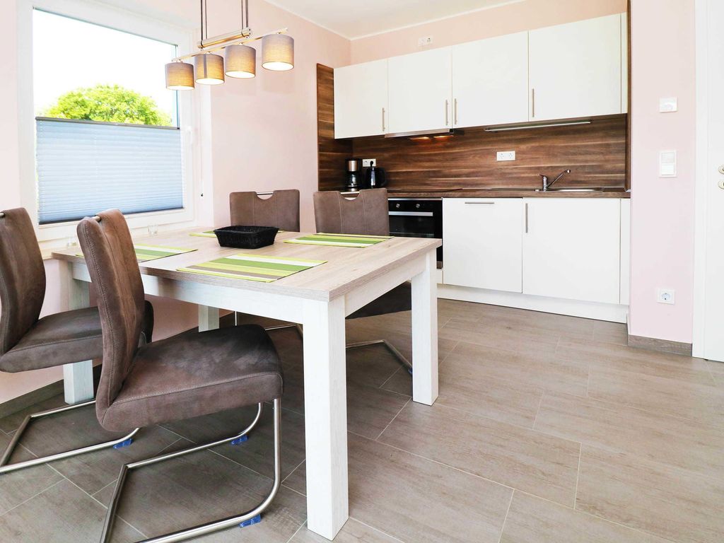 3. Wohn- und Essbereich
Das Ferienhaus Wis im Ostseebad Karlshagen auf der Insel Usedom zeigt den hellen Wohn- und Essbereich mit Esstisch und Zugang zur Küche.