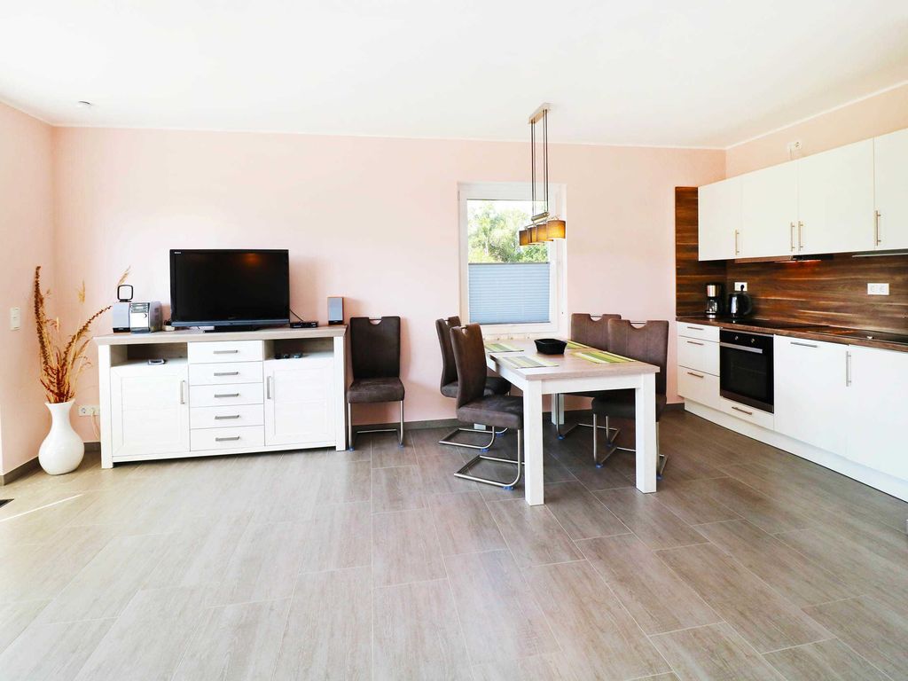 4. Essbereich mit Küche
Das Ferienhaus Wis im Ostseebad Karlshagen auf der Insel Usedom zeigt den Essbereich mit Esstisch und die angrenzende offene Küche.