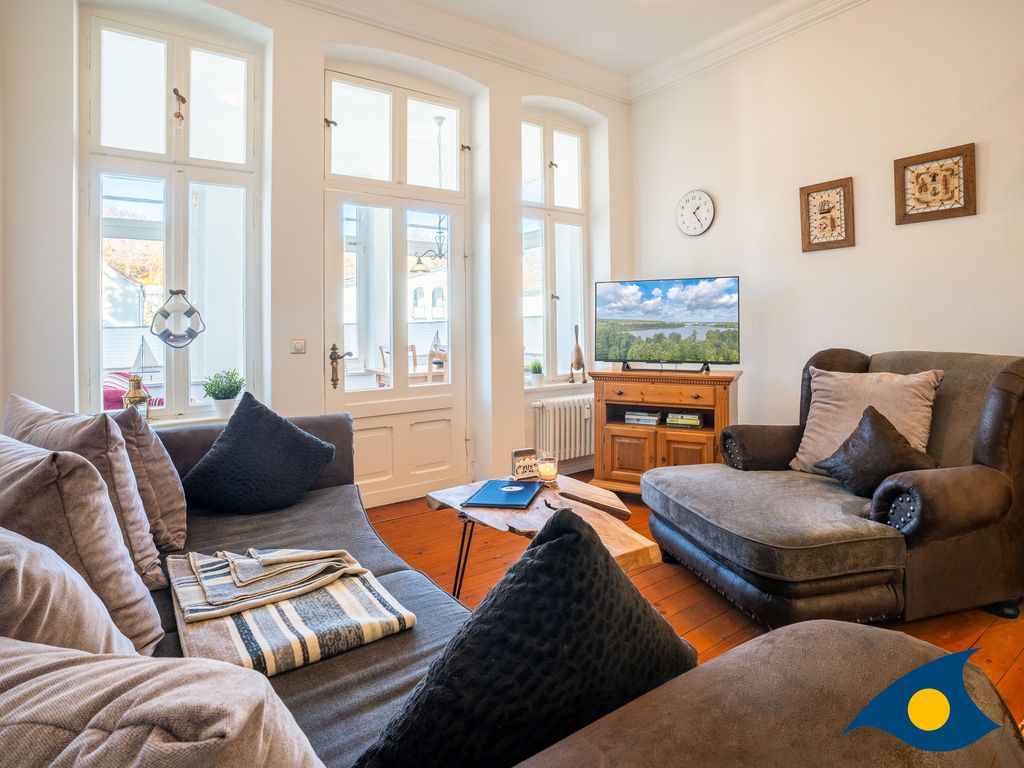 Wohnzimmer mit offener Küche und Zugang zur Loggia