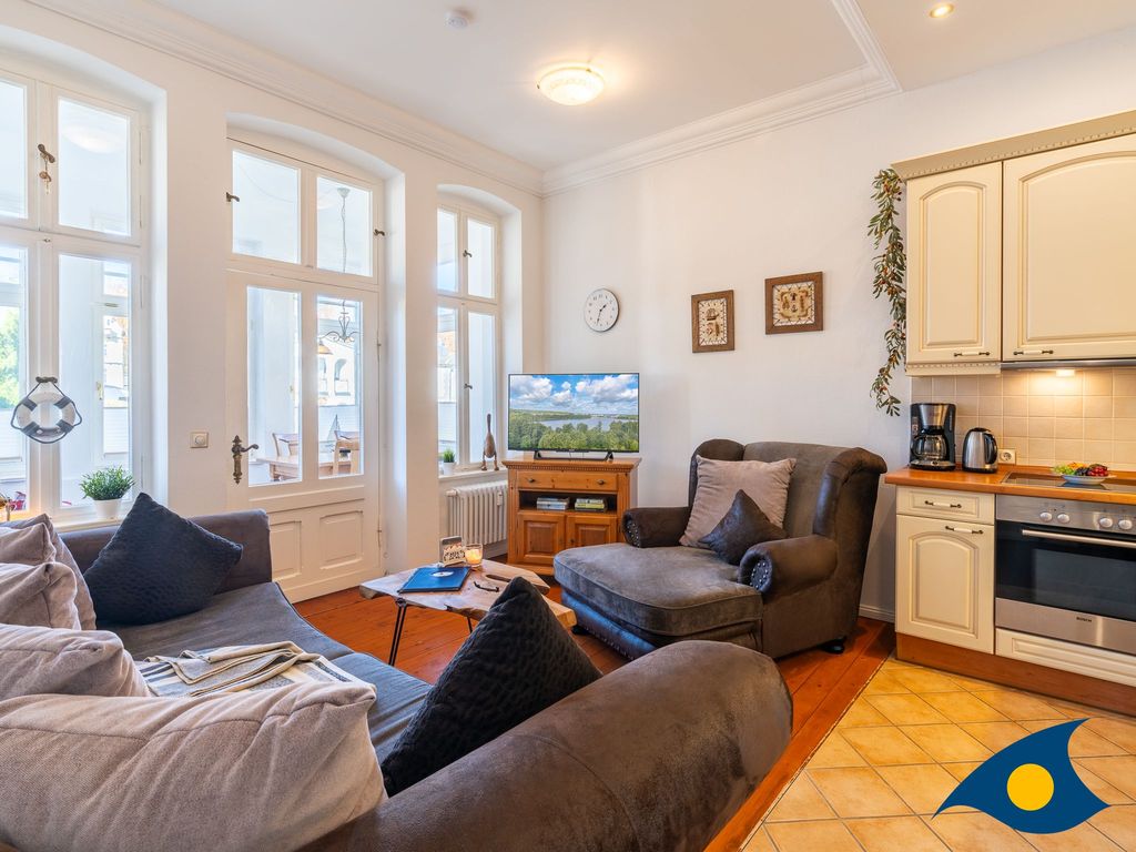 Wohnzimmer mit offener Küche und Zugang zur Loggia