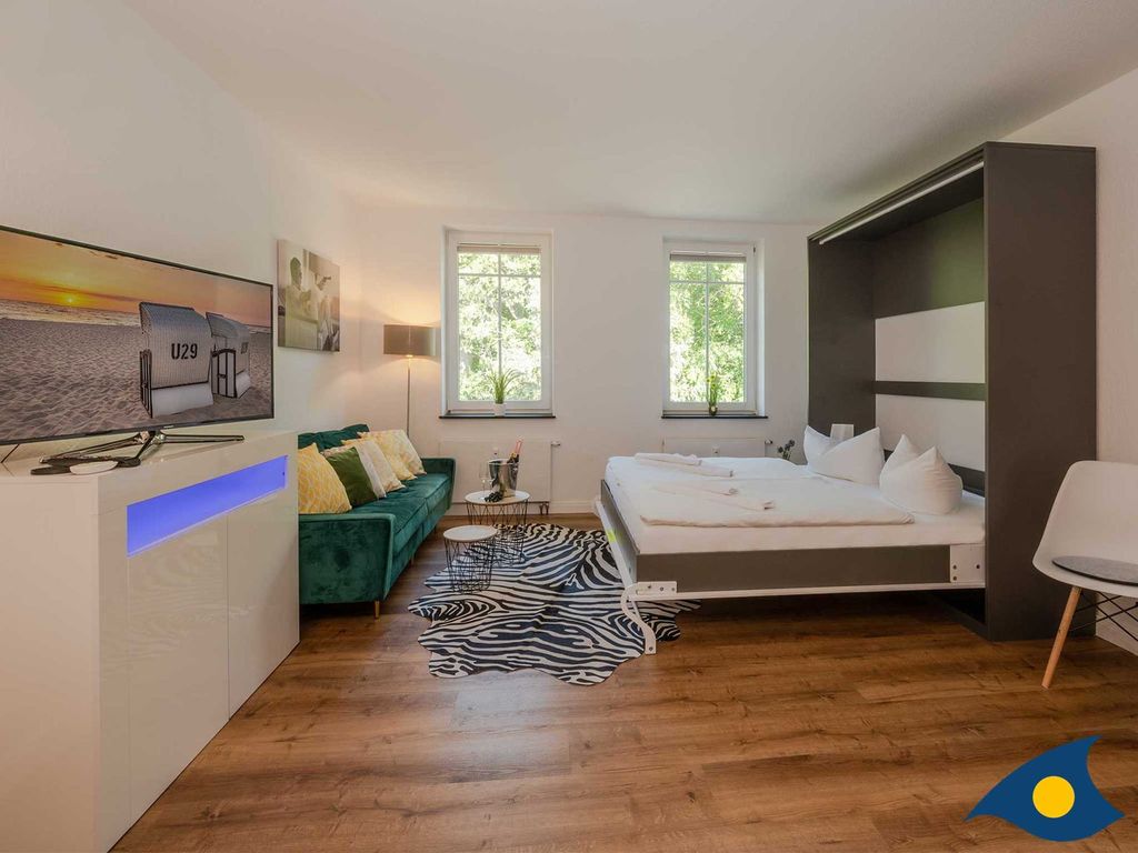 Wohnbereich mit Couch und Bett mit Schlaffunktion