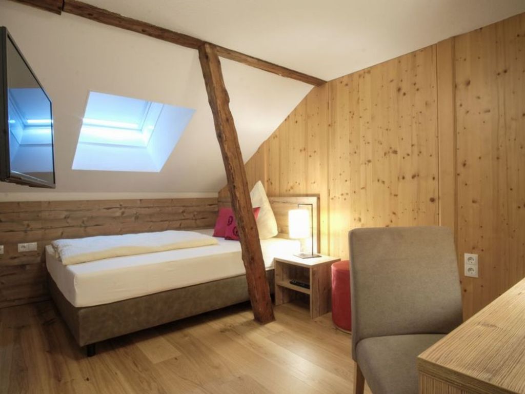 Bett mit Schreibtisch und Dachfenster