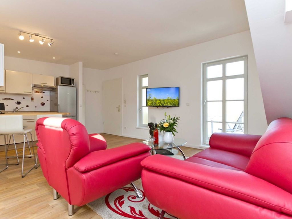 Wohnzimmer mit Essbereich, Küchenzeile und Zugang zum Balkon